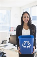 Caucasian businesswoman holding recycle bin