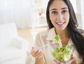 Caucasian woman eating salad