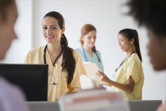 Nurses in colorful scrubs talking in hospital