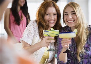 Women toasting each other with margaritas