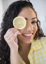 Hispanic woman holding lemon slice