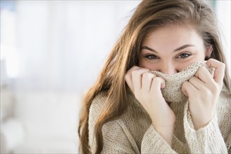 Hispanic girl covering her face with sweater