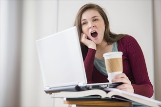 Hispanic girl yawning at desk