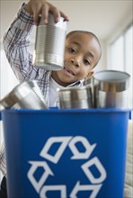 African American boy recycling aluminum cans