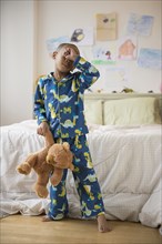 African American boy waking up in bedroom