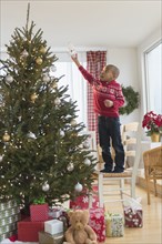 African American boy decorating Christmas tree