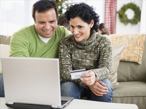 Couple shopping online in living room