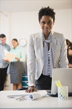 Businesswoman standing at desk in office