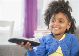 African American girl watching television on sofa