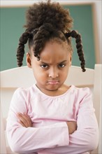 African American girl frowning in classroom