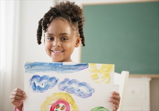 African American girl with painting in classroom