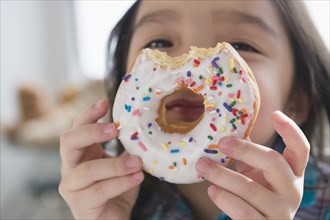 Asian girl peeking through donut hole