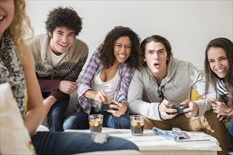 Friends playing video games in living room