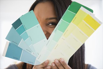 Mixed race woman holding paint swatches
