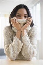 Mixed race woman wrapped in sweater