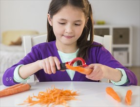 Mixed race girl peeling carrots