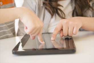 Hispanic girl using tablet computer on desk