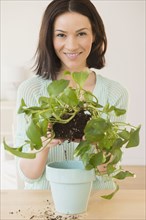 Caucasian woman depotting plant