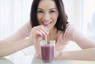 Caucasian woman drinking purple smoothie