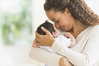 Hispanic mother holding infant son