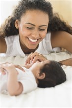 Hispanic mother playing with infant son