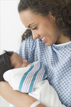 Hispanic mother holding newborn in hospital