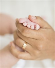 Hispanic mother holding infant's foot