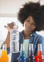 Mixed race woman choosing water over soda