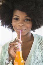 Mixed race woman drinking soda