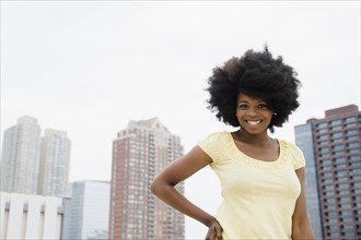 Mixed race woman smiling on urban rooftop