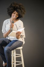 Mixed race woman doing poetry reading on stage