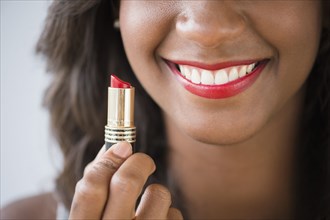 Black woman holding lipstick
