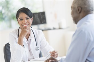 Black doctor and patient talking in office