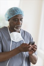 Black surgeon using cell phone