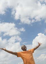 Black man with arms outstretched outdoors