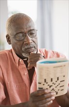 Black man doing crossword puzzle