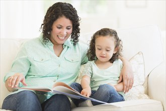 Mixed race mother reading with daughter