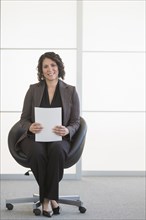 Hispanic businesswoman sitting in office chair