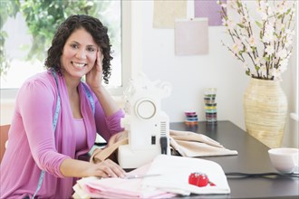 Hispanic dressmaker working at sewing machine