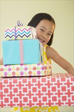 Korean girl holding stack of wrapped gifts