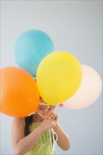 Korean girl hiding behind bunch of balloons