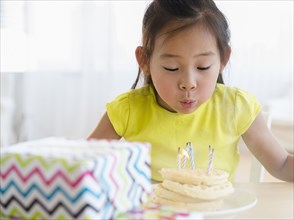 Korean girl blowing out candles on birthday cake