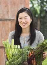 Korean woman carrying basket of vegetables