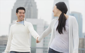 Couple holding hands in city