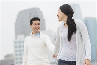 Couple holding hands in city