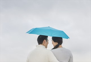 Couple hugging under umbrella
