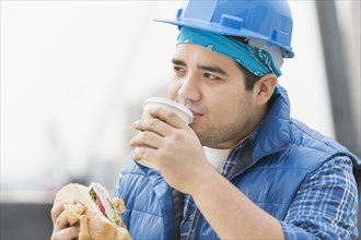 Mixed race worker eating lunch on construction site