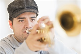 Mixed race man playing trumpet
