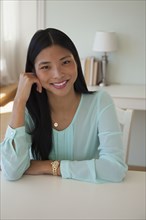 Chinese woman smiling at desk