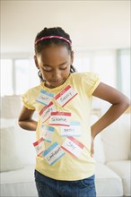 Mixed race girl wearing various name tags